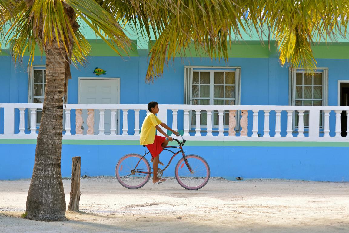 Fahrradfahrer vor blauem Haus in Belize