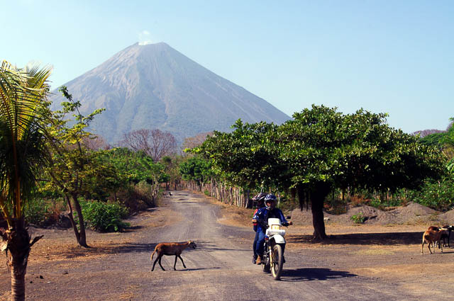 Motorradfahrer auf der Insel Ometepe mit Vulkan im Hintergrund