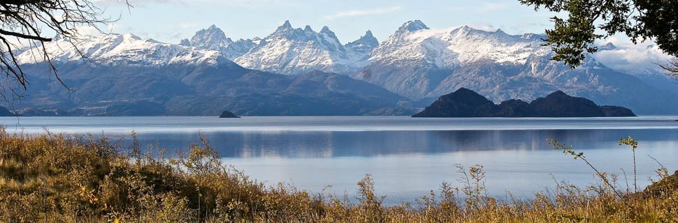 Blick über eine Wiese auf einen chilenischen See